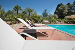 - une piscine avec 2 chaises longues à côté de la piscine dans l'établissement Villa Fortini, à Antella