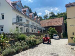 einem roten Traktor, der vor einer Reihe von Häusern geparkt ist in der Unterkunft Vogtmühle in Roggenburg