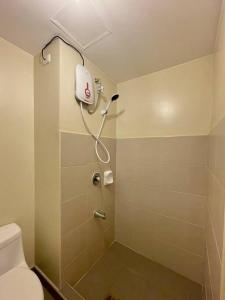 een badkamer met douche en toilet bij * *I2 Sleek City Haven in Iloilo City +4 foto's