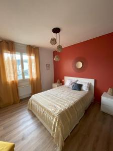 1 dormitorio con 1 cama con pared roja en Charmante maison individuelle à Limoux, en Limoux