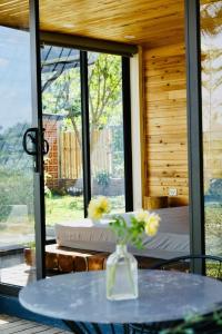 a room with a bed and a table with flowers on it at Sóc Sơn Homestay - Bird House in Sóc Sơn