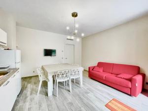 uma sala de estar com um sofá vermelho e uma mesa em La Corte di Nonna Ada em Pianillo