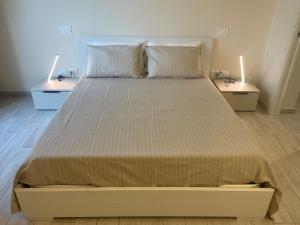 a large bed in a bedroom with two night stands at Casa Piccolo Charme e Design nel cuore di Maderno in Toscolano Maderno