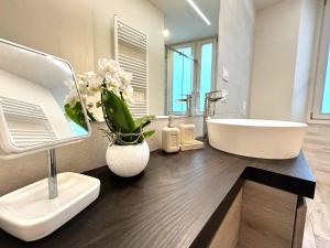 a bathroom with a sink and a white tub at Casa Piccolo Charme e Design nel cuore di Maderno in Toscolano Maderno