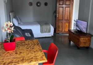 a bedroom with a bed and a table and chairs at Stay-A-While by Ustay in Saldanha