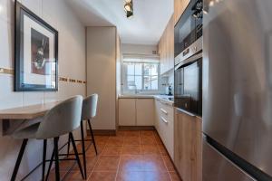 a kitchen with a table and chairs and a refrigerator at Oasis Mijas Centro in Mijas +12 photos