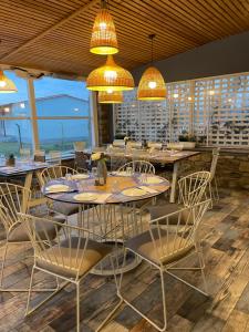 a dining room with tables and chairs and chandeliers at Isalos Suites in Nea Peramos