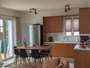 a kitchen with a table and chairs and a refrigerator at Villa Claudia in Apolpaina