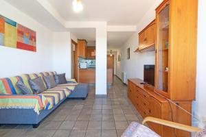 Global Properties, Apartamento con vistas a la playa في بويرتو دي ساغونتو: غرفة معيشة مع أريكة ومطبخ