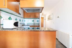 a kitchen with a counter top and a microwave at Global Properties, Apartamento con vistas a la playa in Puerto de Sagunto