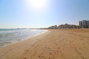 a sandy beach with buildings and the ocean at Global Properties, Apartamento con vistas a la playa in Puerto de Sagunto