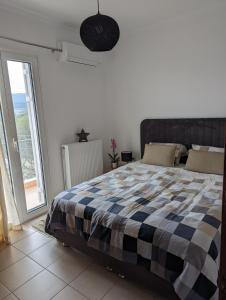 a bedroom with a bed with a checkered blanket at Villa Claudia in Apolpaina +25 photos