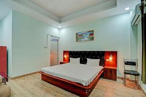 a bedroom with a large bed and a chair at OYO Royal SIV Galaxy in Kānpur