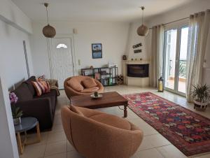 a living room with a couch and chairs and a table at Villa Claudia in Apolpaina