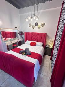 a bedroom with a red bed with a red headboard at Golden Dreams Lodging Home in Camalaniugan