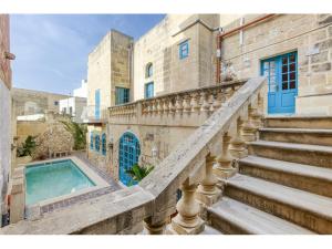 Un escalier mène à une maison avec piscine. dans l'établissement Authentic 4 Br Gozitan Farmhouse with Private Pool by 360 Estates, à L-Għarb
