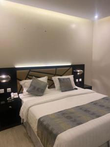 a bedroom with a large bed with two pillows at رفان للشقق المخدومة in Khamis Mushayt