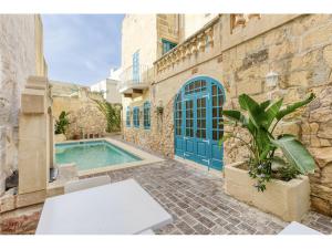 une maison avec une piscine et une table blanche dans l'établissement Authentic 4 Br Gozitan Farmhouse with Private Pool by 360 Estates, à L-Għarb