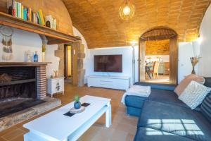 een woonkamer met een bank en een open haard bij Can Tarana in Santa Cristina d'Aro