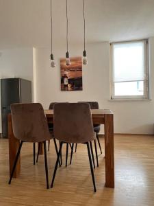 einen Esstisch mit Stühlen im Zimmer in der Unterkunft Tobi‘s Ferienapartment in Gottmadingen