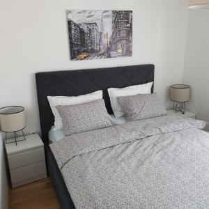 a bedroom with a bed with two night stands and two lamps at JR Lux apartman in Stara Pazova