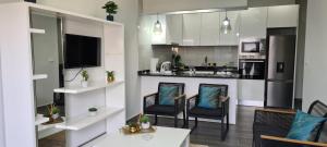 uma cozinha com duas cadeiras e uma mesa num quarto em Cazino Apartamento 4 em Praia