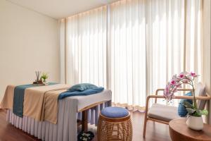 a bedroom with a table and a chair and a window at TTC Van Phong Bay Resort - Himalaya Sauna & Steam Retreat Included in Ninh Hòa