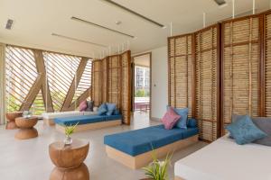 a living room with two blue couches and windows at TTC Van Phong Bay Resort - Himalaya Sauna & Steam Retreat Included in Ninh Hòa