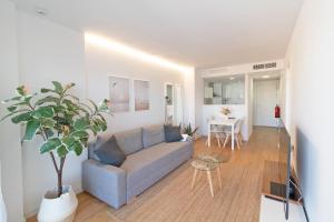 ein Wohnzimmer mit Couch und Tisch in der Unterkunft Global Properties, Moderno apartamento con piscina y terraza en la playa de Canet in Canet d'en Berenguer