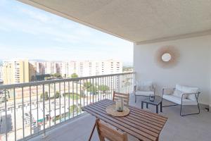 balcón con mesa, sillas y vistas a la ciudad en Global Properties, Moderno apartamento con piscina y terraza en la playa de Canet, en Canet de Berenguer