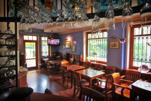 ein Esszimmer mit Tischen und Stühlen und Fenstern in der Unterkunft Willa Amor in Krynica Morska