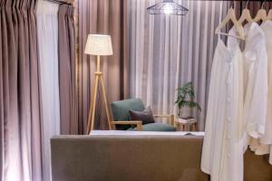ein Ankleidezimmer mit einem Bademantel, einem Stuhl und einer Lampe in der Unterkunft Adama Villas & Guesthouses in Mouresi