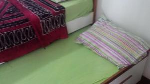 um quarto com 2 camas com verde e vermelho em Apartamento Barra da Tijuca com vista espetacular no Rio de Janeiro