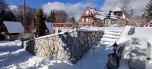 科帕奧尼克的住宿－Apartmani Vujanac，雪中带围栏的房子