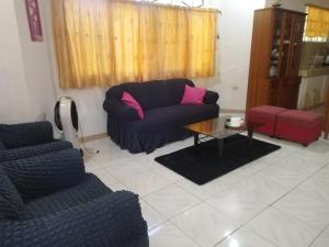 sala de estar con sofá y 2 sillas en Banaga Residence, en Talibon