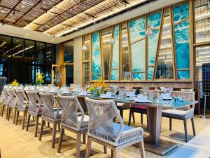 uma longa sala de jantar com uma longa mesa e cadeiras em TTC Van Phong Bay Resort em Ninh Hòa