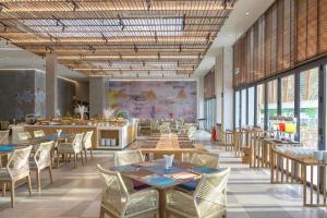 a dining room with tables and chairs and windows at TTC Van Phong Bay Resort - Himalaya Sauna & Steam Retreat Included in Ninh Hòa