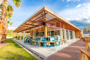 un grand bâtiment avec des tables et des chaises bleues dans l'établissement TTC Van Phong Bay Resort, à Ninh Hòa