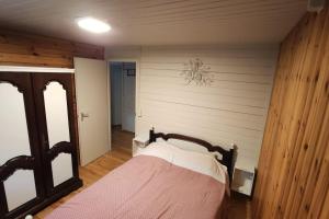 ein Schlafzimmer mit einem Bett in einem Zimmer mit einer Wand in der Unterkunft Chalet nature au cœur des Ardennes in Somme-Leuze