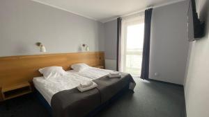 a bedroom with a bed with two towels on it at Hotel Galion in Gdańsk