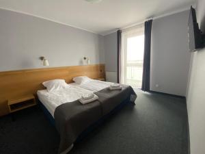 a bedroom with a bed and a large window at Hotel Galion in Gdańsk