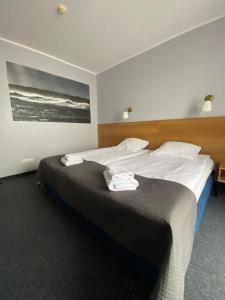 a bedroom with a large bed with towels on it at Hotel Galion in Gdańsk