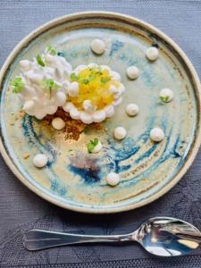 a plate of food on a table with a spoon at Dimitile Hôtel & Spa in Entre-Deux