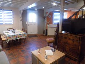 a living room with a table and a flat screen tv at Meschers sur Gironde - MAISON mitoyenne EN PIERRES - proximité commerces in Meschers-sur-Gironde