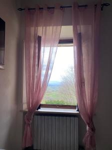 a window with pink curtains in a room at Casa Borghellina in Montaione