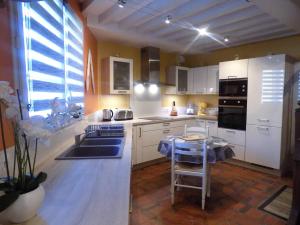 a kitchen with white cabinets and a sink and a counter at Meschers sur Gironde - MAISON mitoyenne EN PIERRES - proximité commerces in Meschers-sur-Gironde