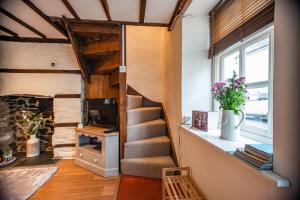 escalera en una habitación con chimenea de piedra en Central Brecon, Pretty Victorian Cottage, en Brecon