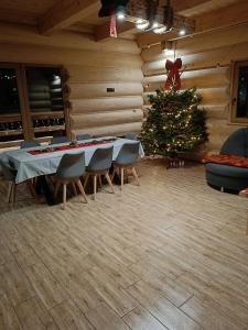 a christmas tree in a room with a table and chairs at Domek u Sołtyska in Rajcza