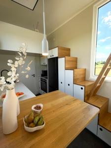 a kitchen with a table and a vase with a bowl of fruit at Tiny House Alpakablick - inklusive gratis Alpaka Meet & Greet in Borken
