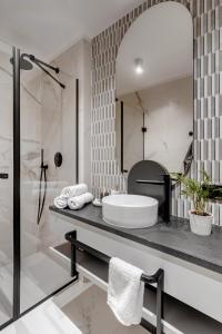 a bathroom with a tub and a sink and a shower at MameHome Apartments in Krakow